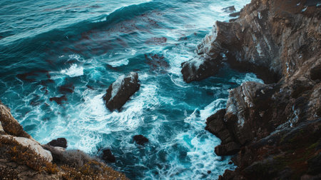A stunning coastal cliff with waves crashing against the rocks belowの素材