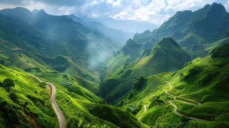 A beautiful mountain vista with a winding road and lush green valleysの素材