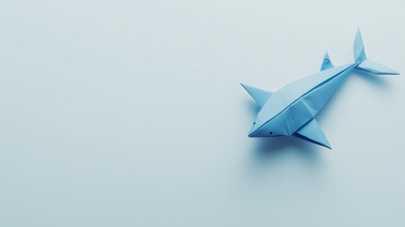 An adorable blue origami shark placed on a light background, showcasing creativity and simplicity. Perfect for art and craft themes.の素材