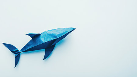 This image features a blue origami shark on a light background, highlighting the elegance of paper art. Perfect for creative and educational themes.の素材