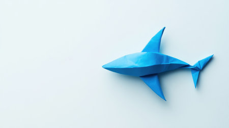 A vibrant blue origami shark crafted from paper, showcasing artistic skill and creativity. This minimalist design is perfect for marine-themed projects or educational purposes.の素材
