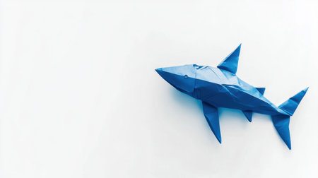 A striking blue paper shark origami piece on a clean white background. Perfect for illustrations related to marine life, creativity, and art crafts.の素材