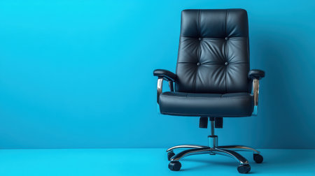 A modern black leather office chair with chrome accents, isolated on a bright blue backdrop for a professional look.の素材