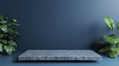 A modern stone table sits elegantly against a dark blue wall, surrounded by lush green plants. Ideal for showcasing products or creating a calming atmosphere.の素材