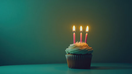 A beautifully crafted cupcake topped with creamy frosting and three vibrant candles, ideal for birthday celebrations or festive events, adding a touch of sweetness to any moment.の素材