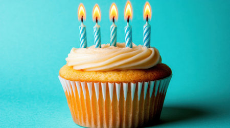 A delightful birthday cupcake topped with creamy frosting and six glowing candles, set against a vibrant teal backdrop, perfect for any festive celebration.の素材