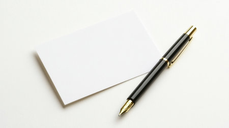 A stylish black pen lies next to a blank white card on a clean surface, perfect for jotting down notes, creative ideas, or formal presentations in an elegant manner.の素材