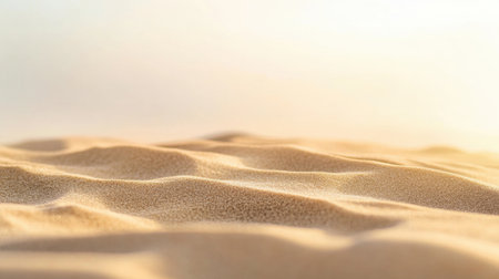 Soft golden sand dunes undulate gently under warm sunlight, offering a tranquil and peaceful atmosphere perfect for relaxation and exploration in a desert landscape.の素材