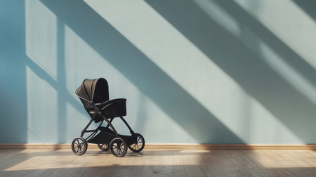 A stylish black baby stroller positioned against a soft blue wall, capturing natural light and shadows, perfect for highlighting modern parenting aesthetics and home design.の素材