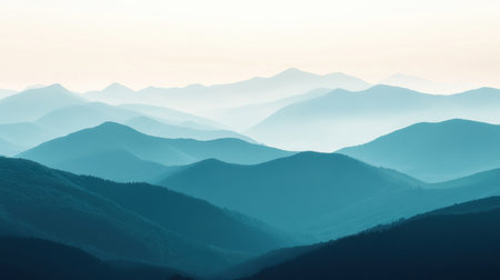 A captivating view of overlapping mountains shrouded in mist, creating a serene atmosphere. The soft hues of blue and green convey tranquility, perfect for nature themes.の素材