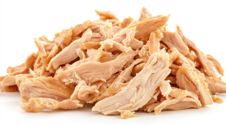 Close-up image of shredded chicken meat on a clean white background, perfect for culinary presentations, recipes, and healthy meal preparations.の素材