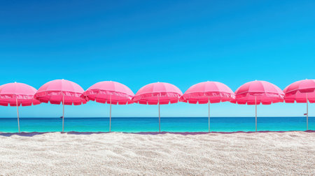 A row of pink beach umbrellas stretches across the soft sandy shore under a clear blue sky. The inviting ocean creates a serene atmosphere perfect for relaxation.の素材