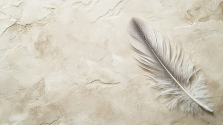 A soft white feather gracefully rests on a textured beige background, creating a serene and peaceful composition ideal for artistic and creative projects.の素材