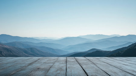 A breathtaking view of serene mountains under a clear blue sky, featuring a rustic wooden deck in the foreground. Perfect for travel and nature themes.の素材