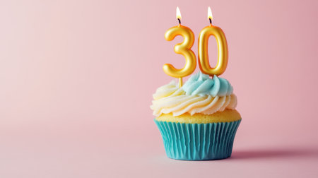 A delightful birthday cupcake featuring vibrant frosting and a bright number 30 candle, set against a soft pink background, perfect for celebration themes.の素材