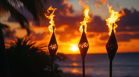 Stunning tropical sunset showcasing flaming tiki torches by the ocean. The scene captures a vibrant sky filled with warm colors, creating a serene atmosphere perfect for relaxation.の素材