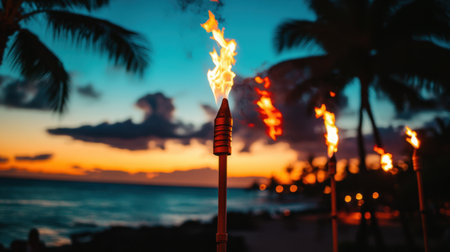 A stunning beach scene showcasing tiki torches emitting flames against a colorful sunset and silhouetted palm trees, creating a serene tropical atmosphere.の素材