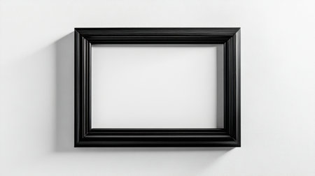 A stylish black frame set against a white wall, ideal for showcasing art or photography. Perfect for modern interiors and creative projects.の素材