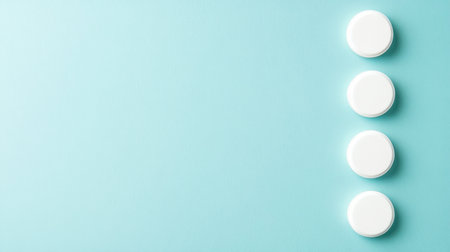 A captivating arrangement of four white round containers on a soft light blue background. Ideal for showcasing products, branding, or advertising in a professional and minimalist style.の素材