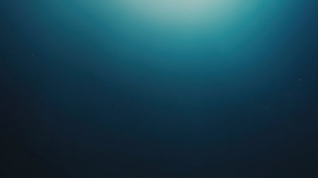 This image captures a tranquil underwater scene, featuring soft light rays filtering through deep blue water, creating a serene and peaceful ambiance.の素材