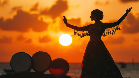 A graceful silhouette of a dancer captured at sunset, performing amidst drums, embodying vibrant cultural expressions and the beauty of artistic celebration in nature.の素材