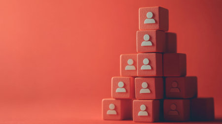 Red block with leader symbol atop stacked cubes with team icons, symbolizing structured leadership and organizationの素材