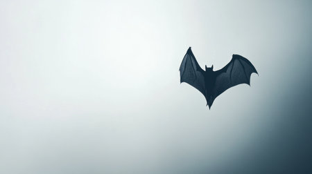 A captivating silhouette of a bat in flight against a soft, foggy background. This image evokes a sense of mystery and elegance, celebrating the beauty of nocturnal wildlife.の素材