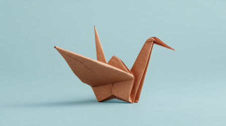 A beautiful origami sculpture showcasing a meticulous transformation of rough paper into a flying bird, highlighted against a soothing blue backdrop. Perfect for art and craft themes.の素材