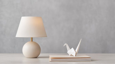 This tranquil workspace features a soft glow lamp beside an elegant origami bird, perfect for promoting creativity in a modern, minimalist environment.の素材