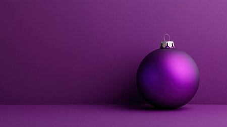 A vibrant purple Christmas ornament rests on a matching purple background, creating a striking visual for holiday decor and festive arrangements.の素材