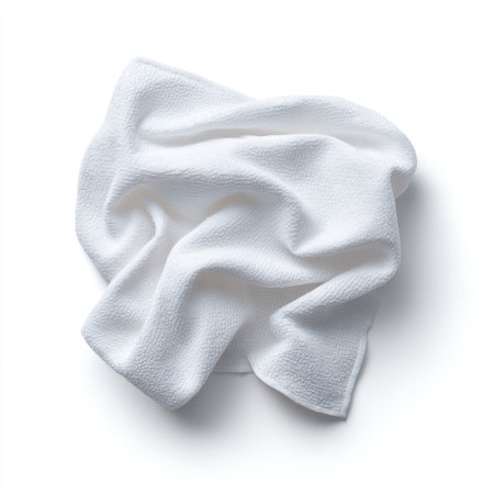 A soft white towel laid out on a white background showcases its texture and elegance, perfect for spa or bathroom settings with a minimalist aesthetic.の素材