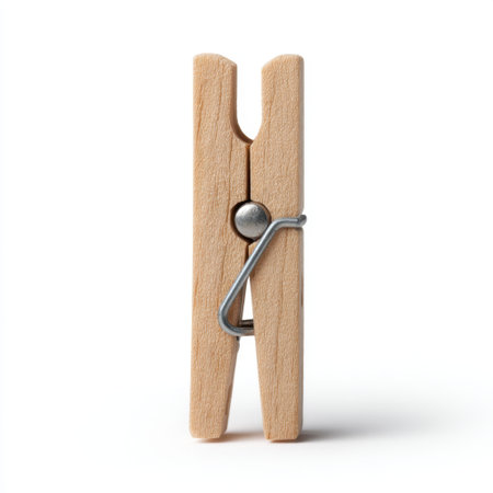 A classic wooden clothespin stands upright on a white surface, showcasing its simple and practical design ideal for laundry and creative projects.の素材