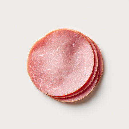 Mouthwatering slices of freshly prepared ham displayed on a soft neutral background, perfect for food photography, cookbooks, and menus highlighting delicious pork dishes.の素材