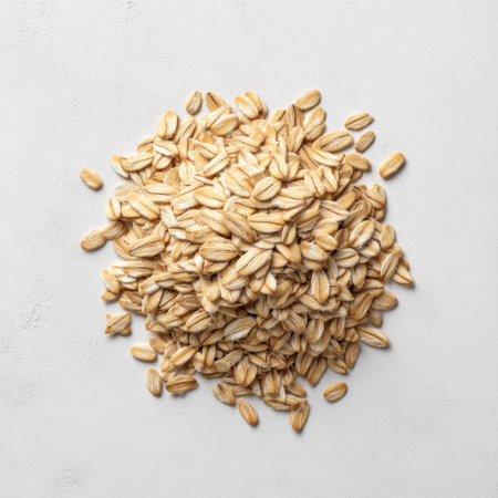 This image showcases a pile of raw rolled oats on a light background, emphasizing their natural texture, perfect for healthy cooking and nutritious breakfast recipes.の素材