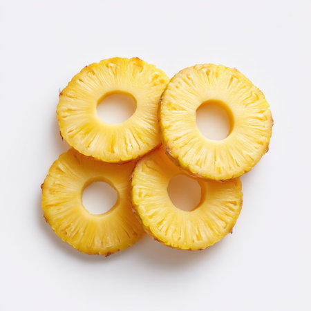 A beautiful arrangement of fresh sliced pineapple rings with a light background, ideal for culinary presentations, health-related themes, and summer recipes.の素材