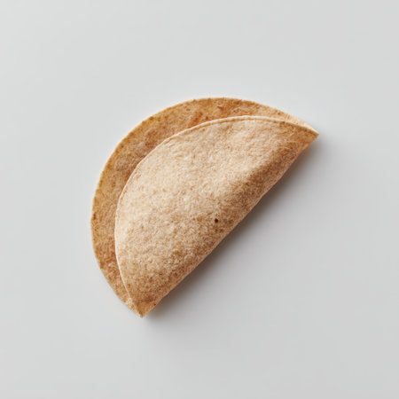 A simple yet elegant image of a folded whole wheat tortilla resting on a clean background. Ideal for healthy cooking, meal preparation, and culinary presentations.の素材