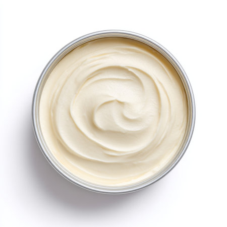 This image showcases a creamy and smooth white cosmetic cream in a round tin container, ideal for representing skincare essentials and beauty routines.の素材