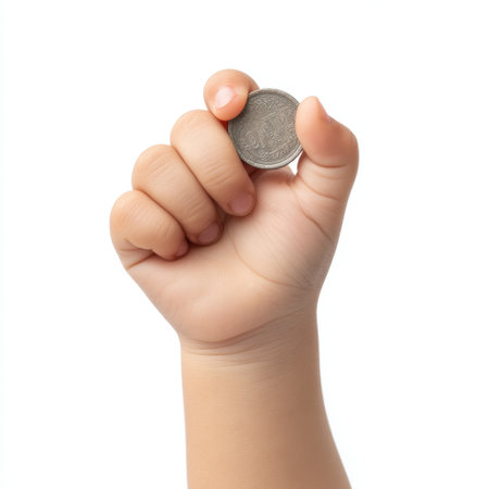 A child hand firmly grasps a coin, symbolizing curiosity and excitement, perfect for themes of finance, childhood, and exploration in educational contexts.の素材