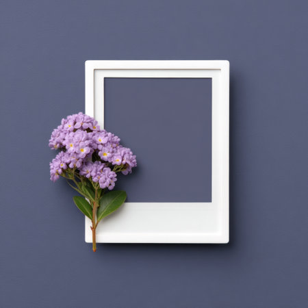 A minimalist composition featuring a vibrant bunch of purple flowers beside a white empty photo frame. Perfect for themes of creativity, memories, or natural beauty.の素材