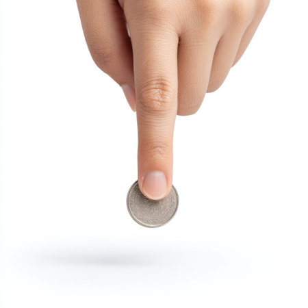 A close-up image showcasing a hand delicately dropping a coin in a minimalistic studio setting, highlighting the gesture and texture of the coin for financial themes.の素材