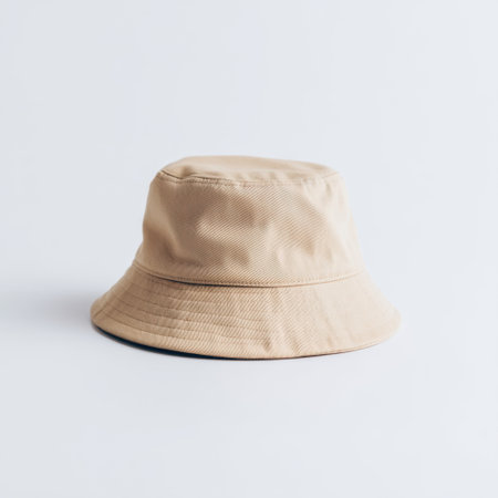 A stylish beige bucket hat set against a white background, perfect for summer outings, outdoor adventures, and casual wear. Elevate your fashion statement and stay protected.の素材