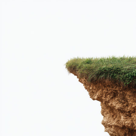 A vibrant green grass patch clings to the edge of a rocky cliff, contrasting beautifully with the soft light of the cloudy sky, creating a serene natural scene.の素材