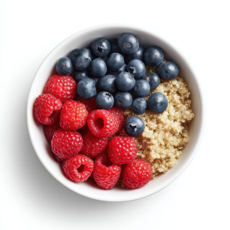 A vibrant bowl filled with fresh raspberries and blueberries alongside fluffy quinoa, ideal for promoting healthy eating habits and colorful appetites.の素材