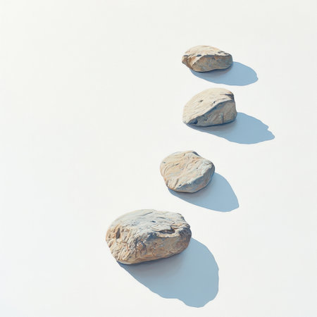 A serene arrangement of smooth, round stones placed on a light background. The shadows and textures create an inviting atmosphere for creative designs and calming aesthetics.の素材