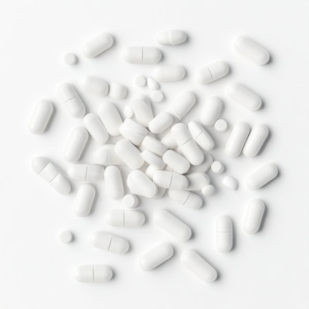 A collection of white pills and capsules arranged on a clean surface, symbolizing health and wellness, used in medical and pharmaceutical contexts for diverse applications.の素材