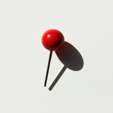 A vibrant red pushpin creates a striking visual on a clean, white background. This image captures the essence of organization and communication, perfect for various projects.の素材