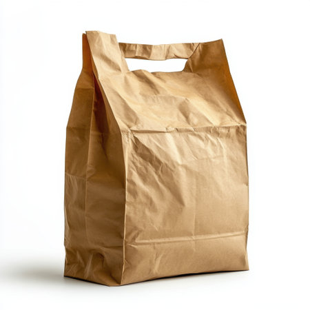This brown paper bag features a simple design with cut-out handles, perfect for carrying food items or groceries, promoting sustainability and convenience.の素材