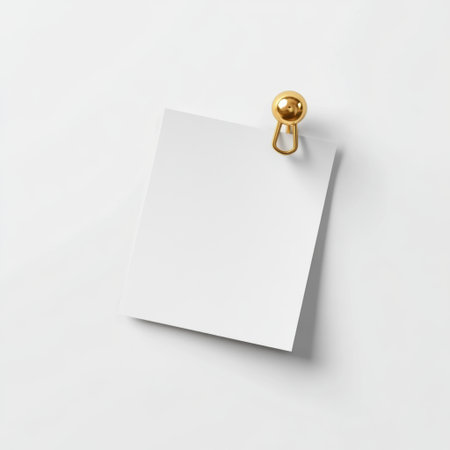 A blank white note paper displays a minimalist aesthetic, pinned with a golden pushpin, perfect for writing messages, reminders, or creative notes.の素材