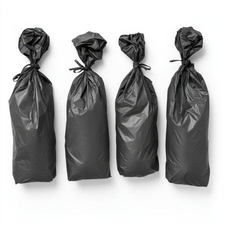 Four black plastic bags are neatly tied and arranged on a clean white background, symbolizing waste management and promoting cleanliness in various settings.の素材