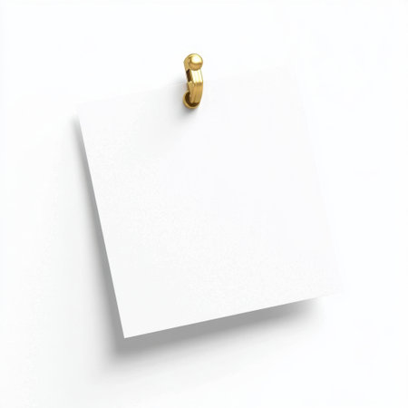 A clean and minimalistic image featuring a blank white note paper hanging on a gold hook. Perfect for design concepts, reminders, or crafting projects against a simple background.の素材